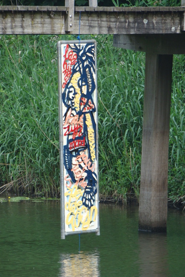 Beschilderd paneel dat aan een brug boven de gracht hangt