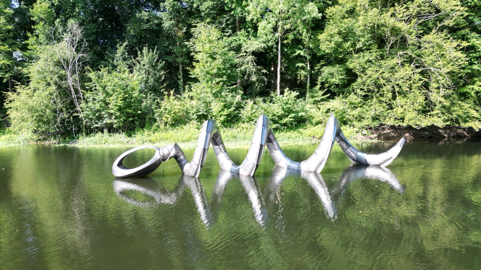 Metalen slangvormig kunstwerk dat uit het water van de gracht in Zaltbommel oprijst